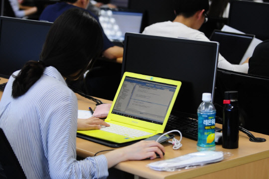 롯데정보통신은 다음달 1일부터 14일까지 IT 직무 역량만으로 인재를 선발하는 '스펙태클' 채용을 실시한다고 24일 밝혔다. 입사 지원자는 스펙을 기재하지 않고 '클라우드 기반 모바일 예약, 결제시스템 개발'을 주제로 직접 프로그램을 제작해 제출하면 된다. 작년 스펙태클 오디션 참가자가 프로그램을 만들고 있다.   롯데정보통신 제공